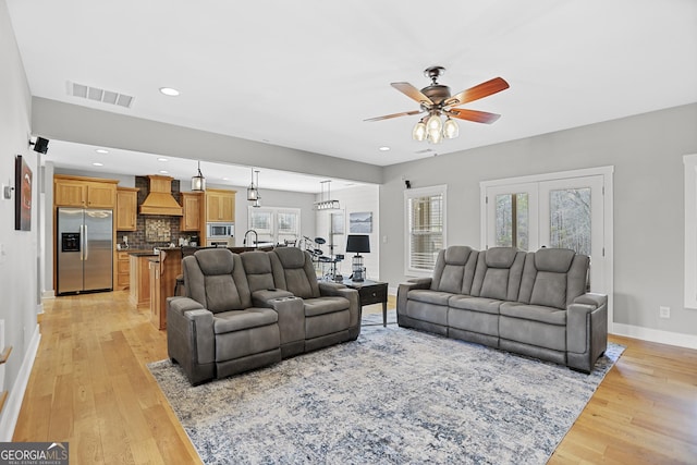 living room featuring ceiling fan, recessed lighting, visible vents, baseboards, and light wood finished floors