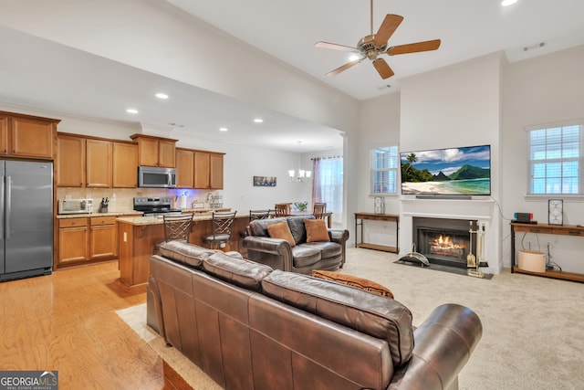 living room featuring a fireplace with flush hearth, recessed lighting, visible vents, and plenty of natural light