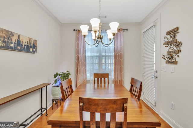 dining room with a chandelier, visible vents, baseboards, ornamental molding, and light wood-type flooring