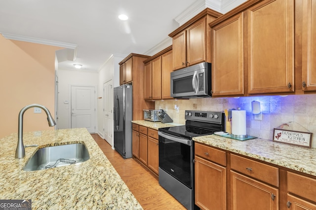 kitchen featuring brown cabinets, stainless steel appliances, decorative backsplash, ornamental molding, and a sink