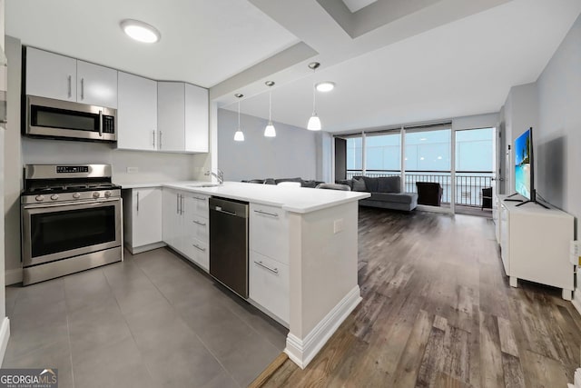 620 Peachtree St Unit 503, Atlanta, GA 30308 - kitchen with light countertops, appliances with stainless steel finishes, open floor plan, a sink, and a peninsula