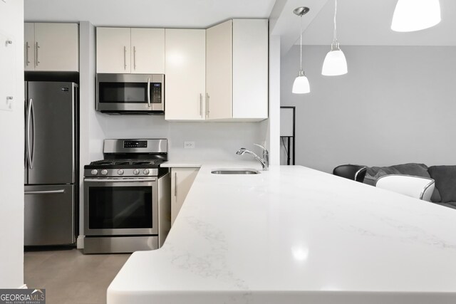 620 Peachtree St Unit 503, Atlanta, GA 30308 - kitchen featuring light countertops, hanging light fixtures, appliances with stainless steel finishes, a sink, and a peninsula