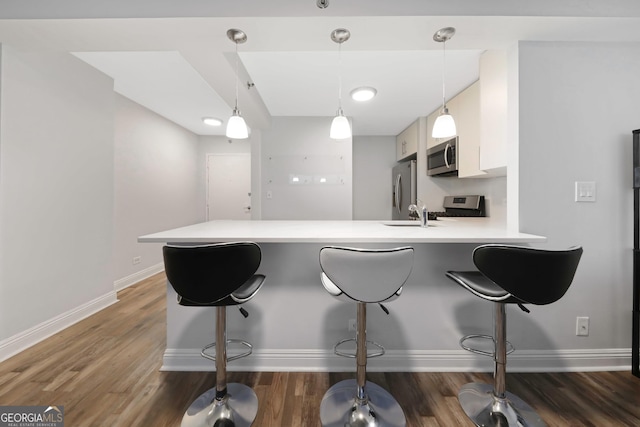 620 Peachtree St Unit 503, Atlanta, GA 30308 - kitchen featuring stainless steel appliances, light countertops, a peninsula, and a kitchen bar