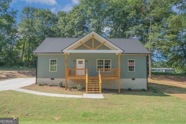 view of front of home with a porch, crawl space, roof with shingles, and a front lawn