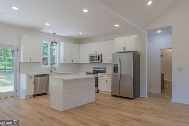 kitchen featuring light countertops, backsplash, appliances with stainless steel finishes, white cabinets, and a sink