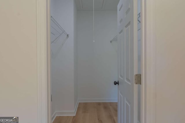 spacious closet with attic access and light wood-type flooring