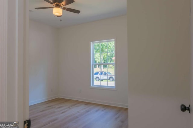 empty room featuring a ceiling fan, light wood-style flooring, and baseboards