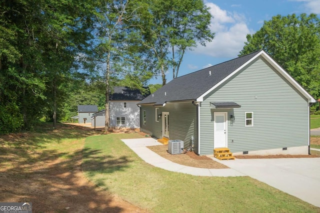 rear view of house featuring entry steps, crawl space, a lawn, and central air condition unit