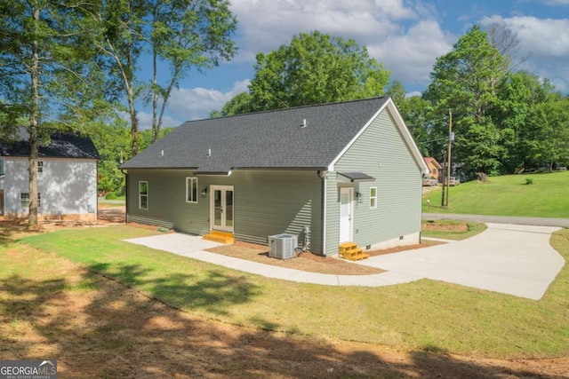 back of property with entry steps, a patio, central AC, french doors, and a lawn