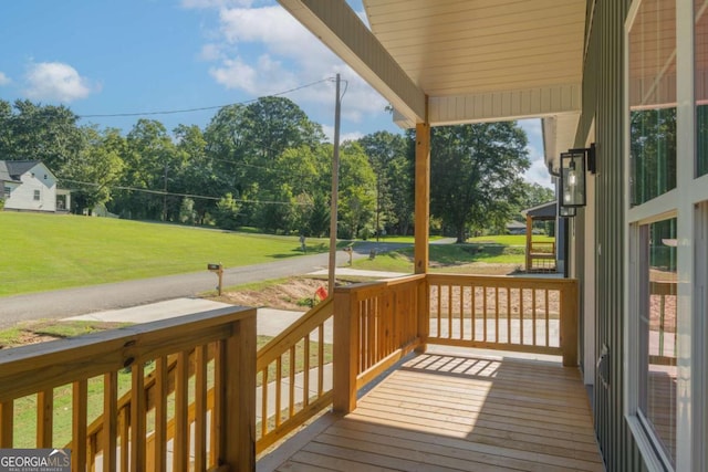 wooden terrace with a lawn