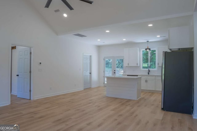 kitchen featuring freestanding refrigerator, visible vents, light wood finished floors, and white cabinetry