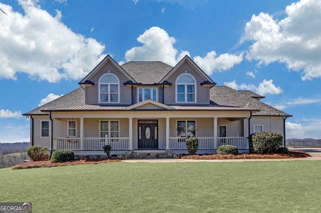 view of front of property featuring covered porch, a shingled roof, and a front yard