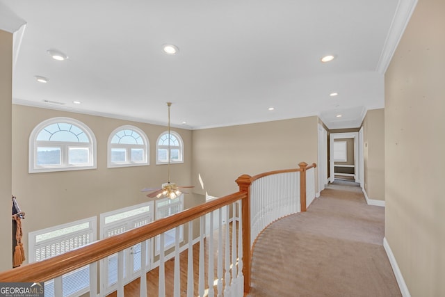 hall with recessed lighting, light colored carpet, an upstairs landing, baseboards, and crown molding