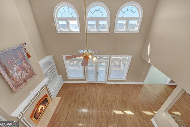 unfurnished living room with a healthy amount of sunlight, baseboards, and wood finished floors