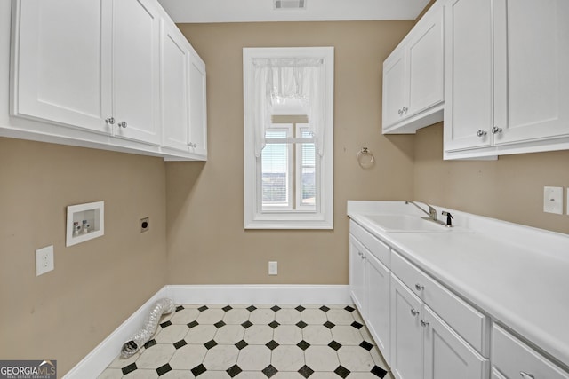 washroom with washer hookup, a sink, visible vents, cabinet space, and light floors