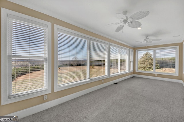 unfurnished sunroom featuring ceiling fan