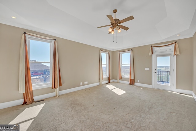 spare room featuring baseboards, visible vents, a tray ceiling, carpet flooring, and recessed lighting