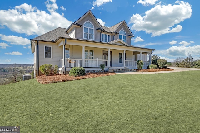 country-style home with covered porch, roof with shingles, central AC, and a front lawn