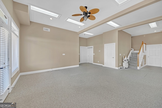 interior space with ceiling fan, lofted ceiling with beams, visible vents, baseboards, and stairway