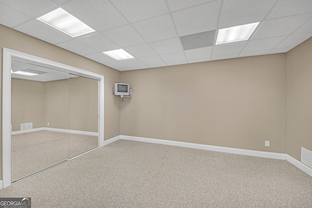 basement with visible vents, carpet, a paneled ceiling, and baseboards