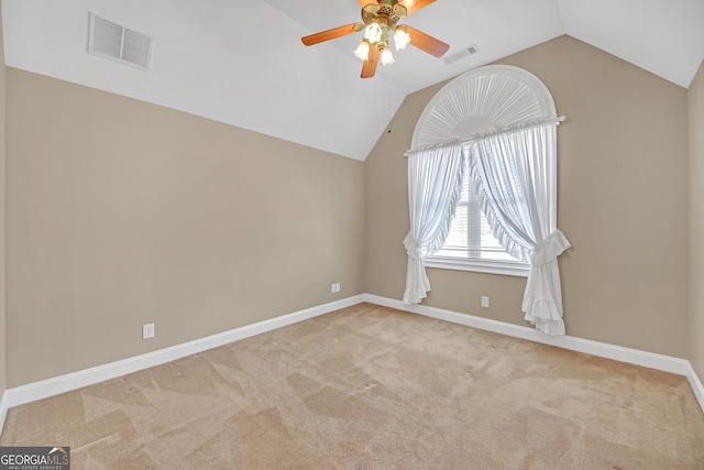 spare room with lofted ceiling, carpet flooring, visible vents, and baseboards