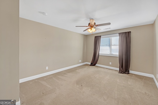 spare room featuring carpet floors, visible vents, ceiling fan, and baseboards