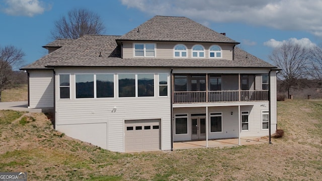 back of property featuring a patio, a garage, a sunroom, a yard, and french doors