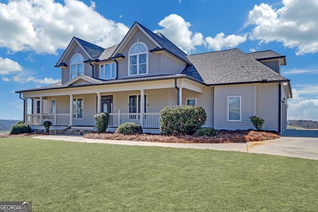 farmhouse with a shingled roof, a porch, and a front lawn