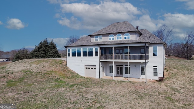 rear view of house featuring a sunroom, french doors, a patio area, and an attached garage