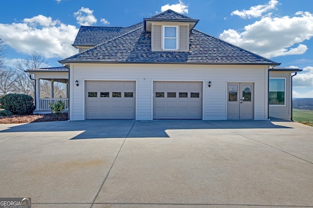 exterior space featuring driveway, a shingled roof, and an attached garage