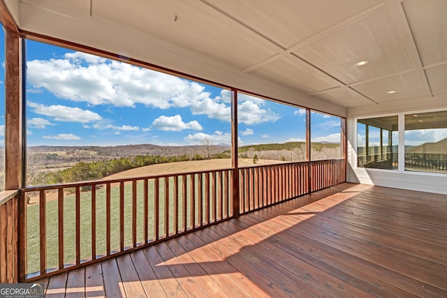 deck with a mountain view and a yard