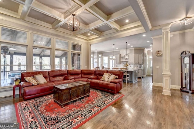 living area with beam ceiling, coffered ceiling, wood finished floors, and decorative columns