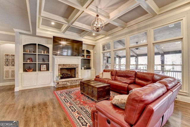 living area featuring coffered ceiling, beamed ceiling, a fireplace, and wood finished floors