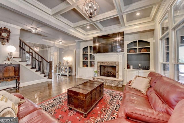 living area with coffered ceiling, crown molding, and stairs