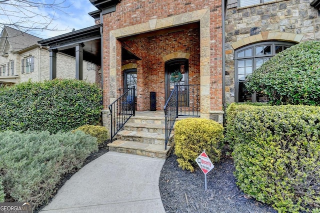 doorway to property with stone siding and brick siding