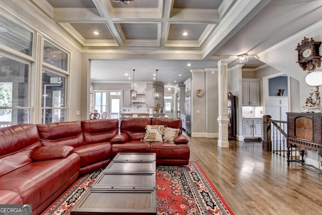 living area with coffered ceiling, dark wood-style floors, beamed ceiling, crown molding, and ornate columns