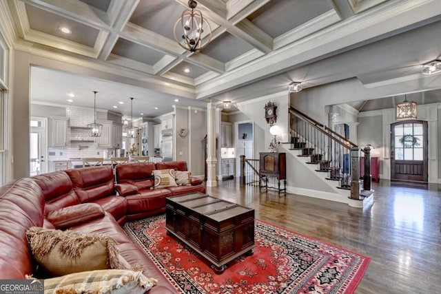 living area featuring coffered ceiling, an inviting chandelier, stairs, crown molding, and beam ceiling