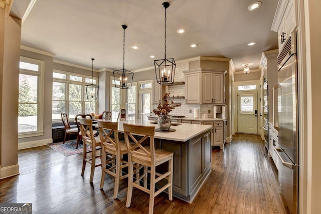 kitchen with a wealth of natural light, a center island, light countertops, and decorative backsplash