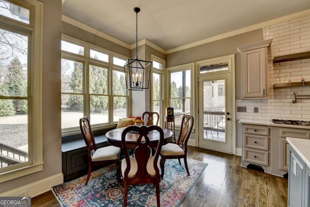 dining room with baseboards, ornamental molding, a chandelier, and dark wood-type flooring