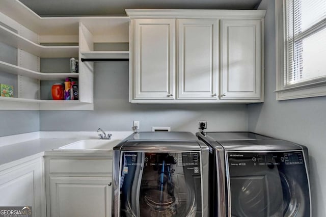 laundry area with washing machine and dryer, cabinet space, and a sink