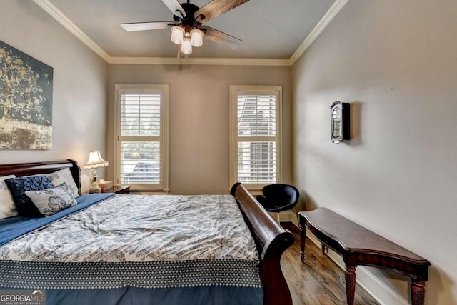 bedroom with ornamental molding, multiple windows, and wood finished floors