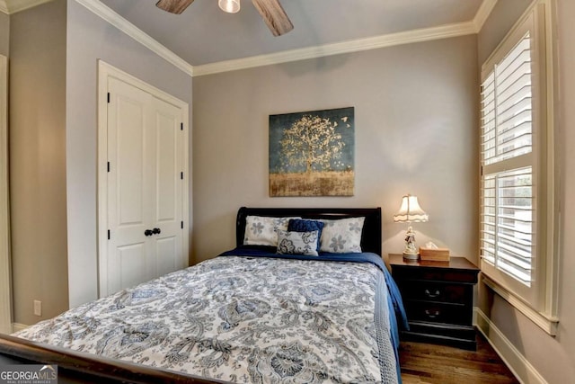 bedroom featuring baseboards, a ceiling fan, wood finished floors, crown molding, and a closet