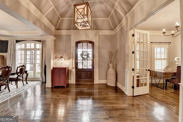 entryway with arched walkways, a healthy amount of sunlight, lofted ceiling, and an inviting chandelier