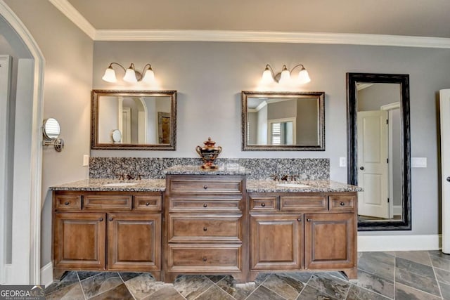 bathroom featuring double vanity, crown molding, and a sink