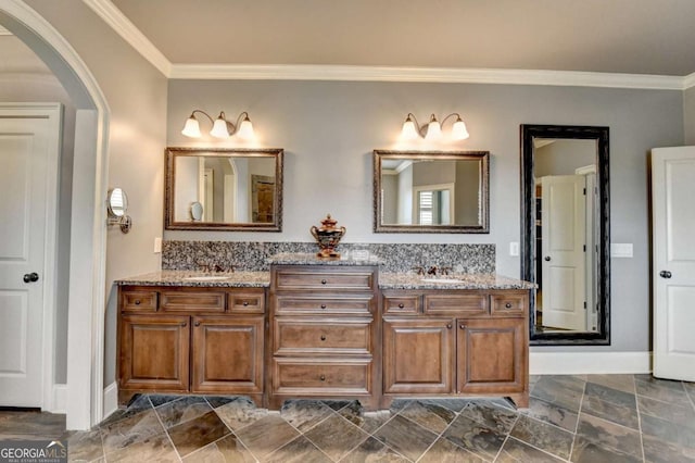 bathroom with ornamental molding, a sink, and double vanity