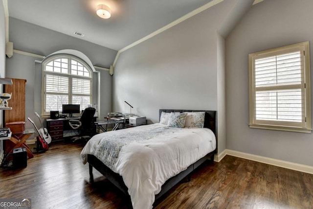 bedroom with crown molding, lofted ceiling, visible vents, wood finished floors, and baseboards