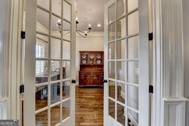 interior space featuring ornamental molding, wood finished floors, and french doors