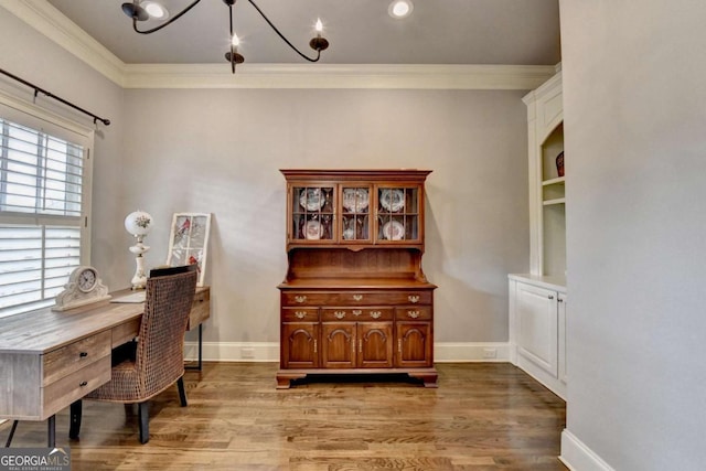 office featuring light wood-style floors, crown molding, and baseboards