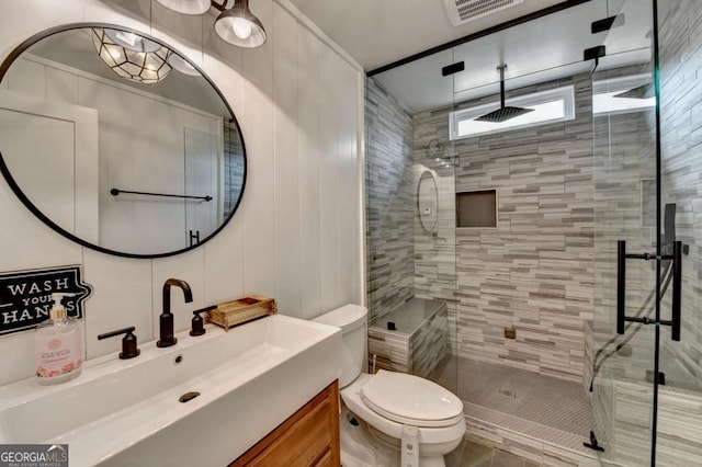 full bath with visible vents, a stall shower, vanity, and toilet