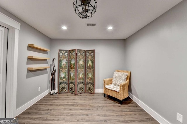 living area with baseboards, visible vents, wood finished floors, and recessed lighting